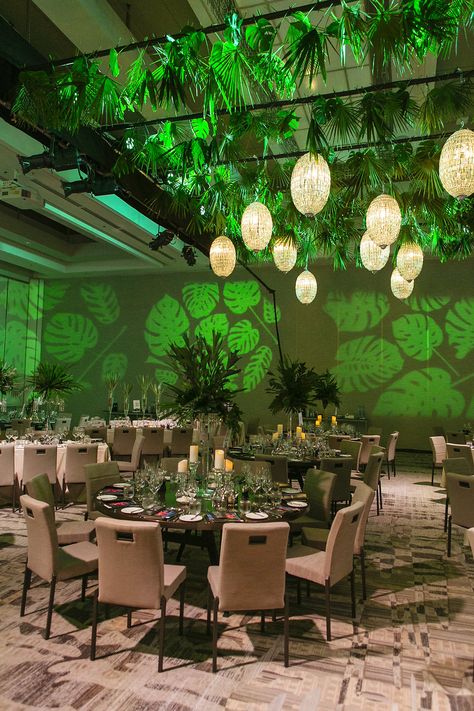 Beautiful mix of glam and tropical leaves bring this event to life, using pattern projection on the walls makes you feel surronded by the jungle. Flowers @flowerzvancouver1 Decor @flowerzvancouver1 Planner Coco Events Photography @lorimiles12 Venue JW Marriot Parq Vancouver Jungle Theme Event Decor, Tropical Event Design, Tropical Corporate Event, Jungle Theme Event, Safari Gala, Tropical Glam Decor, Prom Committee, Forest Theme Party, Rainforest Theme