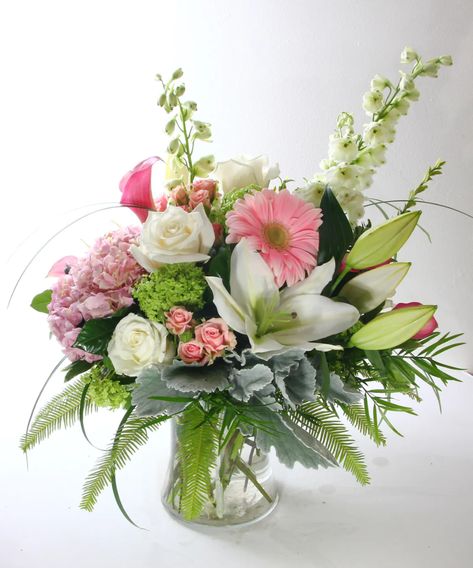 This large vase arrangement will make anyone's day! A lush assortment of pink and white flowers is arranged in a glass vase. The assortment includes lilies, roses, hydrangea and calla lilies. #KittelbergerFlorist Vase White Flowers, Large Vase Arrangements, Seasonal Plants, Easter Lilies, Hydrangea Flower Arrangements, Large Glass Vase, Spring Arrangements, Silk Arrangements, Table Flower