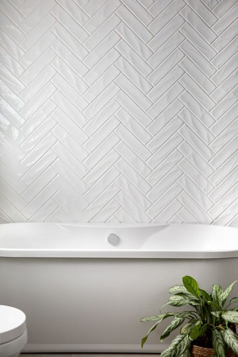 Bathroom White Herringbone Tile, White Herringbone Tile Fireplace, Herringbone Shower Tiles, Backsplash Behind Freestanding Tub, Tiled Wall Behind Freestanding Tub, White Herringbone Fireplace Surround, Herringbone Tile Bathtub Wall, Herringbone Bathroom Wall Tile, Herringbone White Tile Bathroom