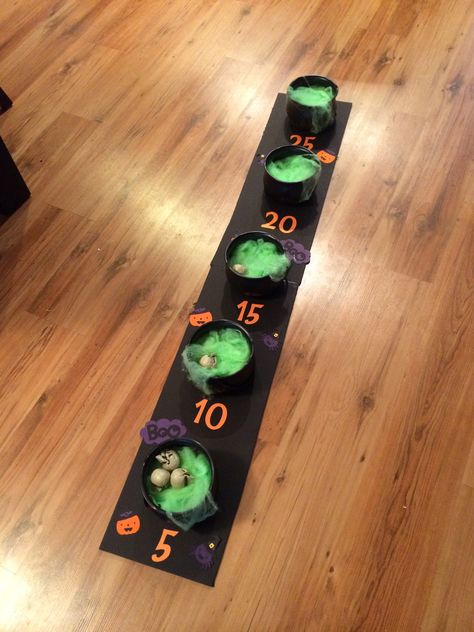 I created this "eyeball toss" game for my daughters halloween birthday party using a foam board, cauldrons from the dollar store and green webbing. I added the numbers and embellishments using my Cricut machine (Create a Critter 2 and George cartridges). We actually used miniature skulls instead of eye balls to toss. Kids had lots of fun! Halloween Punch Out Board, Harvest Halloween Party Ideas, Halloween Ball Toss Game, Diy Cardboard Halloween Games, Halloween Punch Board Game, Monster Mash Party Games, Halloween Yard Games, Halloween Ring Toss, Decor Ideas Birthday