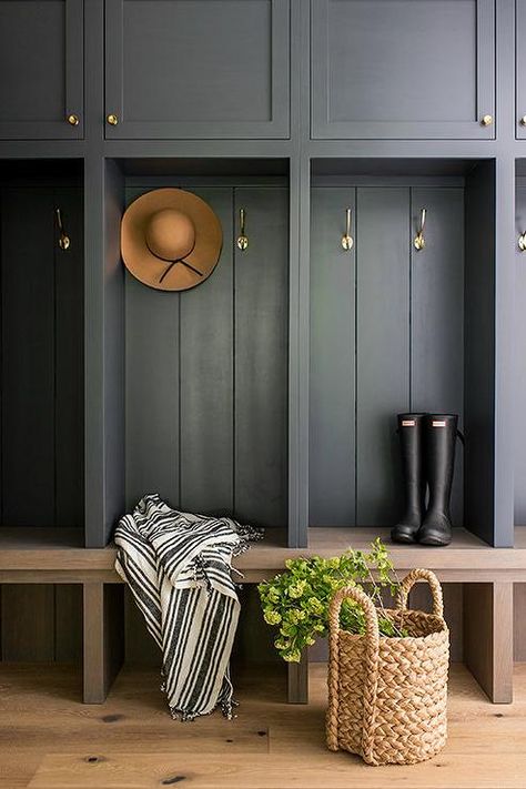 Black shaker cabinets accented with brass knobs are fitted over brass coat hooks mounted against a black plank trim and over a brown oak bench. Going Dark, Mudroom Cabinets, Koti Diy, Greige Design, Mudroom Lockers, Mudroom Entryway, Mudroom Decor, Mudroom Laundry Room, Mudroom Design