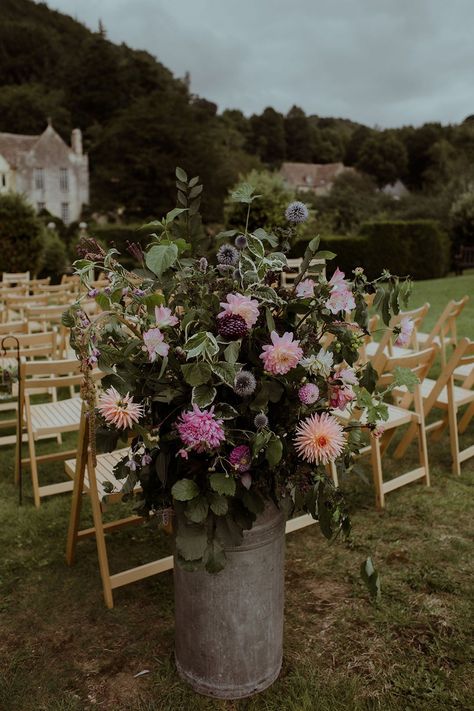 Pink and purple wedding flowers in vintage milk churns including dahlias and thistle Colourful Aisle Flowers, Aisle Meadow Flowers, Meadow Flowers Wedding Aisle, Purple Thistle Bouquet, Scottish Wedding Bouquet Thistles, Pink Purple Wedding, Rock Dresses, Commitment Ceremony, Purple Wedding Flowers