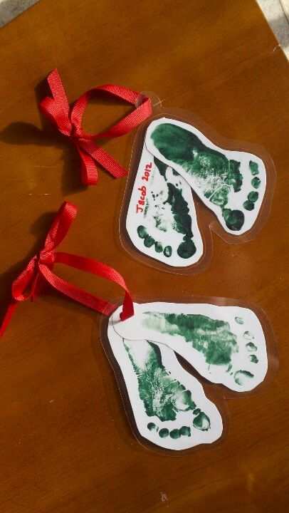 Footprint Christmas tree ornaments (laminated). Easy baby or toddler craft Christmas Laminating Ideas, Laminate Christmas Ornaments, Christmas Craft Toddler Gift, Christmas Gifts Childcare, Christmas Cards For Babies, Christmas Tree Ornaments Homemade Craft Ideas, Infant Daycare Christmas Gifts For Parents, Baby Christmas Ornament Craft, Diy Toddler Christmas Ornaments