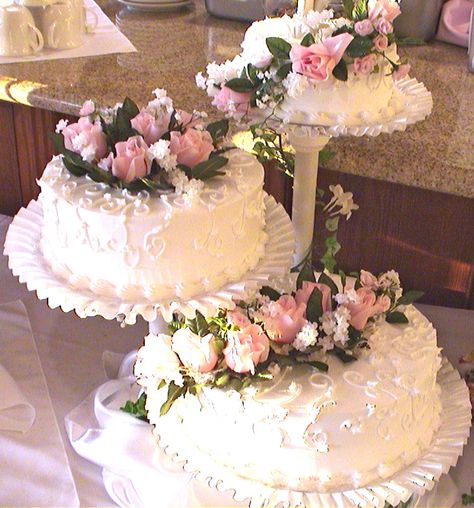 I wanted a plain white wedding cake.. I decorated it with pink silk flowers. Quince Cakes Separate, Plain White Wedding Cake, Wedding Cake Pedestal, Quince Cakes, Wedding Cake Tree, Cake Background, Tier Cakes, Wedding Cake Display, Flowers Simple