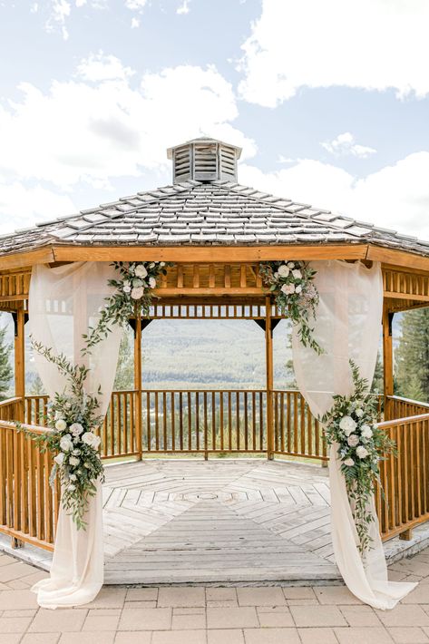 Outdoor wedding gazebo in Canmore, Alberta at Silvertip Resort. Blush and green florals on blush drapery, classic wedding ceremony inspiration. Summer Wedding Outdoor Ceremony, Wedding Gazebo Flowers, Outdoor Wedding Gazebo, Classic Wedding Ceremony, Gazebo Wedding Ceremony, Mountain Portraits, Gazebo Wedding Decorations, Wedding Ceremony Inspiration, Wedding Gazebo