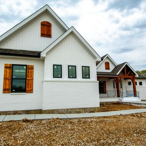 LUXURY FEATURES AND AMENITIES •An Elevated Brick Front Porch with a Black Wrought Iron Rail •Chunky Cedar Post and Beams backdropped by White Board and Batten Siding and Painted Brick •A Modern Kitchen with White Shaker Cabinets, White Granite Tops and White Subway Tile – clean simple lines can are striking. •Kitchen and Great Room Ceilings have complimenting Rustic Beams backdropped with knotty nickel gap. White Brick With Board And Batten Exterior, White Brick And Board And Batten House, Board And Batten Addition To Brick House, Painted Brick And Board And Batten Exterior, White Brick With Board And Batten, Board And Batten Over Brick, Board And Batten Siding Ranch Home, Board And Batten Siding With Brick Ranch, Board And Batten Exterior With Brick