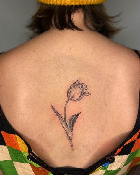 Natalie Andrews on Instagram: "Halli’s tulip. I love this center-back placement! Thank you 🌿" Detailed Tulip Tattoo, Large Tulip Tattoo, Tulip Shoulder Tattoo, Tulip Tattoo Traditional, Tulip Tattoo Back, Tulip Back Tattoo, Tulip Tattoos, Flower Reference, Basic Tattoos