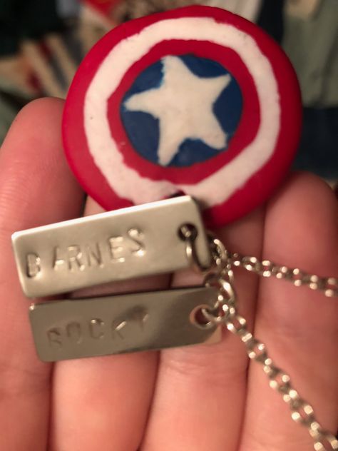 This marvel inspired necklace is a capt. A. shield with bucky barnes name/dog tags. It was fun to make. The shield is made out of polymer clay and the tags are metal with handpunched letters. Bucky Barnes Symbol, Winter Soldier Jewelry, Steve And Bucky Friendship Necklaces, Bucky Barnes Knife Flip, Bucky's Dog Tags, Marvel Bucky, The Shield, Inspired Necklace, Bucky Barnes