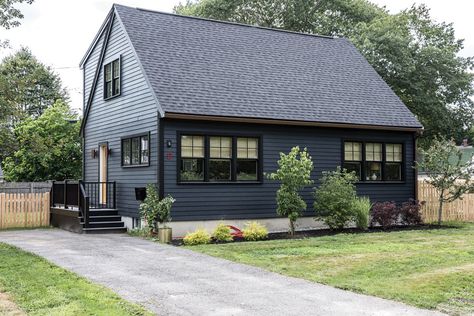 Architectural upgrades and a dramatic palette turn a designer’s whisper-of-a-house into an eye-catching statement. Dark Navy House Exterior Black Trim, Cape Homes Exterior, Black Cape Cod House Exterior, Modern Cape Cod Exterior, Blue House Black Trim, Exterior Cottage, Studio Exterior, Lp Smart Siding, Dark Blue Houses