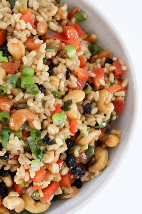 A bowl of brown rice salad filled with cashews, currants, spring onions and chopped red capsicum. Brown Rice Salad Recipes, Best Rice Salad Recipe, Healthy Rice Salad, Salad With Cashews, Vege Dishes, Bean Sprout Salad, Packed Salad, Rice Salad Recipes, Brown Rice Salad