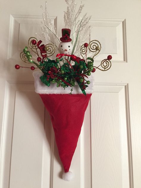 Santa hat door decor for under $10-Dollar store hat, brick of foam, 6 floral picks on sale 50% off-fill the front only! The way it hangs you cannot tell it's not full up! Clip a binder clip on the back  and hang it over the wreath hanger or a nail!!! Dollar Tree Christmas Decor, Front Door Christmas Decorations, Simple Christmas Decor, Dollar Tree Christmas, Pretty Christmas, Christmas Door Decorations, Christmas Crafts Decorations, Christmas Wreaths Diy, Tree Christmas