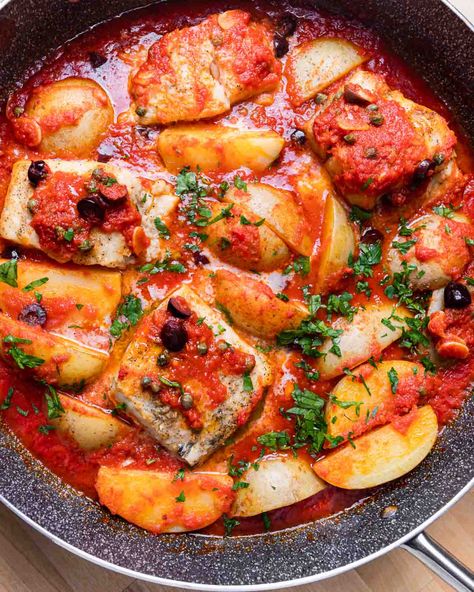 Baccala alla Napoletana is a traditional Italian dish that is best known in America for its appearance in the Feast of the Seven Fishes lineup on Christmas Eve. Salt cod, also known as baccala, is cooked in a garlicky tomato sauce with olives, capers, and potatoes. #baccala #italianfood #sevenfishes #seafood Salted Cod Recipes Portuguese, Italian 7 Fishes Dinner, Italian Fish Dishes, Baccala Recipes Italian, Bacala Recipe, Italian Christmas Eve Dinner Traditional, Bacalao Recipe, Italian Fish Recipes, Cod Stew