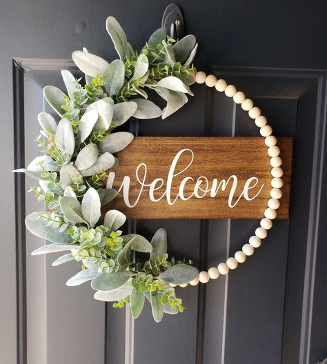 "*This neutral wood beaded hoop wreath is a perfect way to welcome guest for any season! Hang this piece on your front door or in your home for guests to see!  *The wood is stained and the wording is painted of your color choice! The neutral wood beads are threaded through the metal hoop (not glued on). The floral and wood are securely attached to the metal hoop. This sign can be for indoor or outdoor use. I apply an outdoor sealer on the wood. The back of the wood is finished just like the fron Beaded Door Hanger, Front Door Hangers Wooden, Painted Door Signs Ideas, Wreath Alternatives For Front Door, Wooden Wreath Ideas, Wooden Ball Wreath, Diy Welcome Sign Wood, Front Door Wreath Ideas, Beaded Hoop Wreath