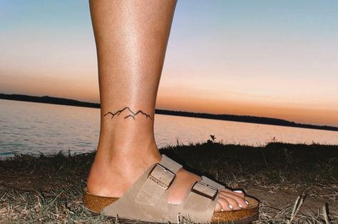 Mountain Tattoo Ankle Band, Mountain Sunset Tattoo Minimalist, Ankle Mountain Tattoos For Women, Elegant Mountain Tattoo, Mountain Ankle Tattoo Wrap Around, Mountain Foot Tattoo, Ankle Tattoo Mountain, Feminine Mountain Tattoo, Mountain Tattoo Ankle