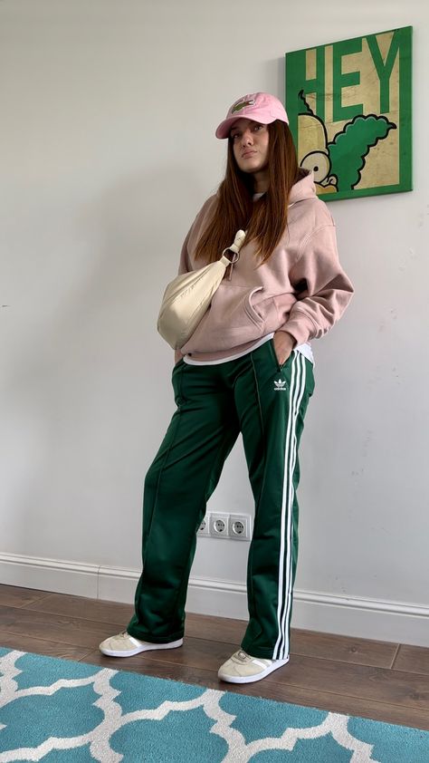 Lacoste cap, pale pink hoodie, green satin Adidas pants, Adidas Gazelle, crossbody bag #ootd #ootdfashion #outfits #outfitideas #streetstyle #style #stylish #styleblogger #styleideas #fashion #lookoftheday Pink And Green Winter Outfit, Green Adidas Pants Outfit, Green Track Pants Outfit, Pink Cap Outfit, Green Sweatpants Outfit, Green Adidas Pants, Green Joggers Outfit, Tracksuit Outfit Women, Adidas Street Style