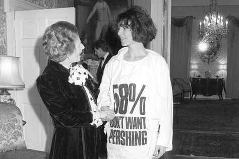 Prime Minister Margaret Thatcher greets fashion designer Katharine Hamnett, wearing at-shirt with a nuclear missile protest message, at 10 Downing Street, where she hosted a reception for British Fashion Week designers, 17 March 1984. Courtesy: PA Images Famous Slogans, Meat Dress, Katharine Hamnett, Angela Davis, Black Panthers, Margaret Thatcher, V Magazine, Moda Paris, Statement Tshirt