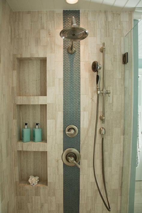 An accent stripe of glass tiles adds interest to this neutral shower. Sleek niches provide storage for shower essentials, and dual shower heads create a luxurious atmosphere. Bathroom Niche, Shower Plumbing, Desain Pantry, Shower Niche, Bathroom Remodel Shower, Bathroom Reno, Shower Shelves, Trendy Bathroom, Shower Remodel