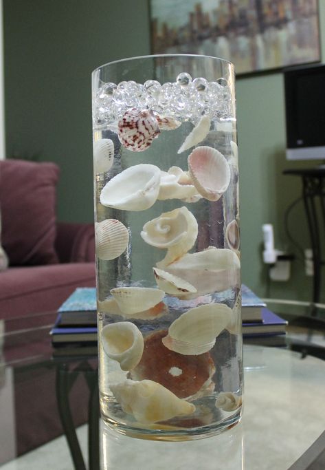 seashells suspended in clear water beads Vase With Clear Water Beads, Water Theme Centerpieces, Gel Water Beads, Orbeez Decorations Ideas, Water Beads Ideas Diy Floating Candles, Clear Water Beads Centerpiece Ideas, Water Beads Ideas Decor, Water Beads Crafts, Orbeez Decor