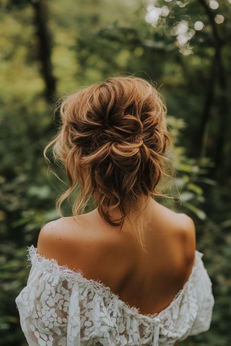 A woman with curly, styled hair stands with her back to the camera, wearing an off-the-shoulder lace dress. She is surrounded by lush greenery in an outdoor setting. Boho Bride Hairstyles Medium Length, Mountain Wedding Hairstyles, Messy Up Do Hairstyles, Curly Styled Hair, Messy Bridal Hairstyles, Boho Updo Wedding, Boho Bride Hairstyles, Brides Hairstyles Medium Length, Messy Bridal Hair