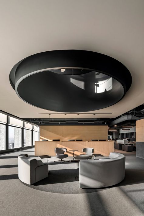 An area on the ground floor is topped by a circular opening to the floor above. There are also benches with stools that wrap around the stairway on this level. Law Firm Office, Large Library, Private Workspace, Architectural Lighting Design, City Office, Law Books, Modular Lounges, H Design, Wooden Staircases