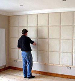 a man putting up padded wall tiles Padded Wall Panels, Mom Bedroom, Fabric Wall Panels, Upholstered Wall Panels, Storage Solutions Bedroom, Bed Headboard Design, Art Walls, Upholstered Walls, Wall Paneling Diy