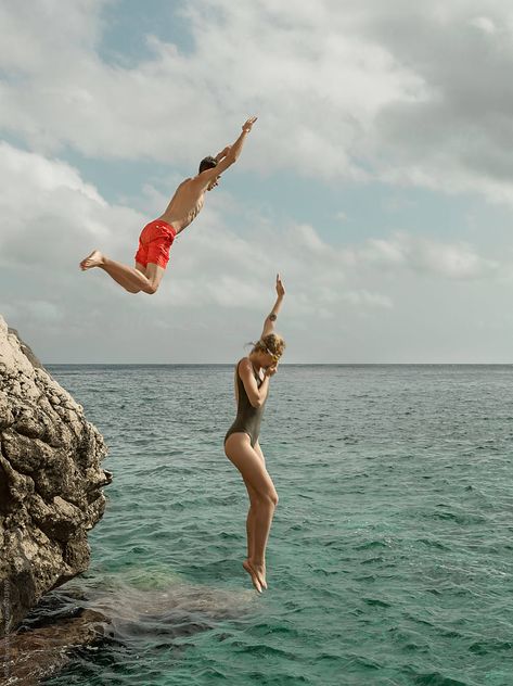 Side view of couple in swimsuit jumping from rock into clean water of ocean lagoon. Attention: models are in a slight motion blur Couple Jumping Into Water, Jumping Into Water Aesthetic, People Jumping Into Water, Man And Woman Aesthetic, People Back View, Jump Into Water, Jumping People, Jumping Into Water, Person Swimming