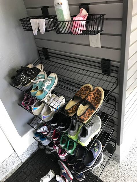 A mudroom, also known as an entryway where you can sit, take off your shoes and coat, can become an additional space in the garage just for you and your family. This is a relatively cost-effective way to vamp up your garage while also transforming it to be more functional. Bringing in a bench, a coat rack and some organizational slatwall baskets or shelves is all that is needed to create a mudroom suitable for easy storage and functionality. #mudroom #garagemudroom #homeorganization #garage Wall Mounted Shoe Storage Garage, Slatwall Mudroom, Shoe Storage Garage Entry, Garage Shoe Storage Wall Shelves, Shoe Organizer For Garage, Garage Coat Rack Ideas, Shoes In Garage Storage Ideas, Garage Shoe And Coat Storage, Garage Organization Shoes