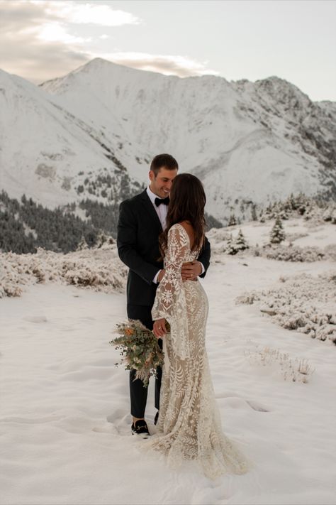 Bride and groom stand in the snow with snowy mountains in the background during sunrise for their elopement. Alaskan Wedding Dress, Mountain Elopement Dress Winter, Winter Elopement Photos, Winter Elopement Photography, Winter Wedding Colorado, Winter Wedding In The Mountains, Montana Winter Wedding, Christmas Elopement Ideas, Elopement In Mountains