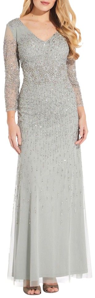 Adorned with shimmering beads, this sparkling gown from Adrianna Papell is sure to add eye-catching sparkle to your evening looks. With a fitted bodice and a flared skirt that creates movement when you walk, the sheer three-quarter length sleeves and a v-neckline create an elegant profile. But it's the sequins that really set this piece apart. Sewn in a gradient with concentrated embellishment around the waistline for a further defined silhouette, pair with simple single-strap heels and a matchi Mesh Gown, Mother Of The Bride Dresses Long, Nylon Dress, Mermaid Evening Dresses, Mac Duggal, A Line Gown, Groom Dress, Bride Dresses, Gorgeous Gowns