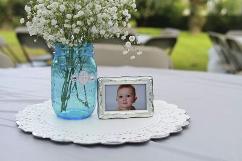 Baby boy baptism centerpiece babies breath blue mason jar frame Baptism Centerpieces For Boys, Boy And Girl Baptism Decorations, Dusty Blue Mason Jar Centerpieces, Baptism Flower Centerpieces Boy, Baptismal Candles Boy Diy, Boy Baptism Centerpieces, Baptism Party Boy, Baptism Decorations Boy, Baptism Pictures