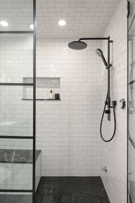 bathroom inspo, white and black bathroom, black faucet, niche design, white subway tile, black floor tile, shower bench, bench inspo. black metal framed glass, black metal shower door Penny Tile Shower Floor, Black Penny Tile, Penny Round Tile Bathroom, Penny Tiles Bathroom, White Subway Tile Shower, Black Faucets, Penny Tile Floors, Black And White Tile, Subway Tile Showers