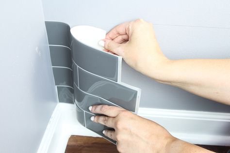 A person peels the back lining off a peel and stick tile. Smart Tiles Backsplash, Laundry Room Refresh, Room Makeover On A Budget, Diy Laundry Room Makeover, Room Wall Tiles, Laundry Room Update, Laundry Room Wall, Small Laundry Room Makeover, Stick Tile Backsplash