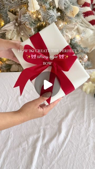 Tara Jane on Instagram: "SAVE THIS ONE 🎀  Follow @our.neutral.abode for more wrapping and decor inspo this Christmas!   I’m so glad I learnt how to do these bows, there’s just something about them being perfect from all angles 🥰🎀✨  Are you an early shopper and wrapper or a last minute Chrissy person? 🎅🏼  #christmasdecor #christmaswrapping #tiffanybow #howtowrapagift" Silver Wrapped Gifts, Christmas Bow Wrapping, How To Wrap Bows On Presents, Christmas Bow Ideas For Gifts, How To Tie Christmas Bows On Presents, Wrap Bows On Presents, How To Make A Christmas Bow For Presents, Kitchen Towel Wrapping Gift Ideas, How To Wrap Bow Around Present