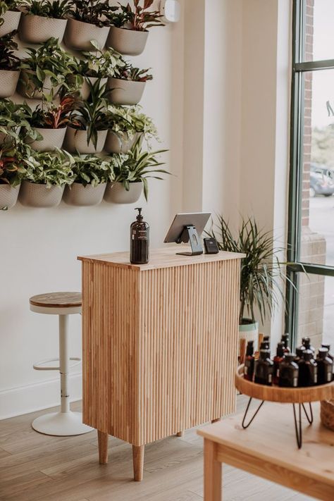 cute modern boho earthy salon decor idea with a plant wall and a clean wood reception desk Diy Reception Desk, Salon Cabin, Boho Salon Decor, Salon Decor Ideas, Tan Salon, Salon Suite Decor, Salon Aesthetic, Small Salon, Spring Garden Decor