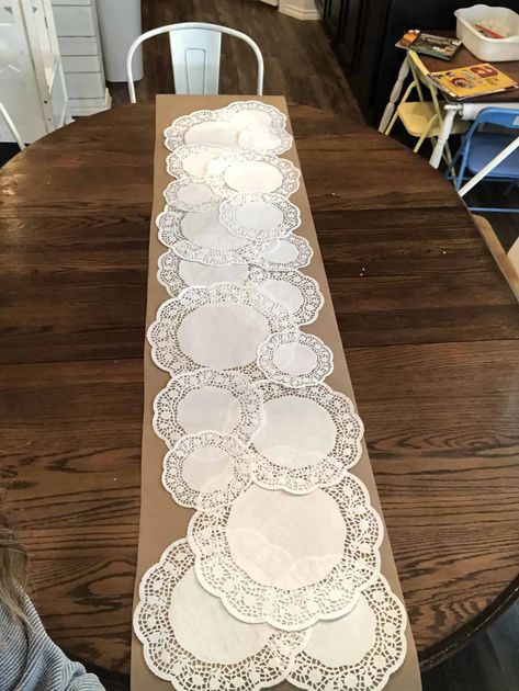 $2 Dollar Tree DIY: How to Make a Paper Doily Table Runner - Her Happy Home Brown Paper Doilies Table Setting, Doilie Table Runner Diy, Doilie Table Runner, Dollie Table Runner, Paper Doily Crafts Wedding, Doilies Centerpiece Wedding, Tulle Table Runner Diy, Tea Party Dollar Tree, Dollar Tree Table Runner Ideas