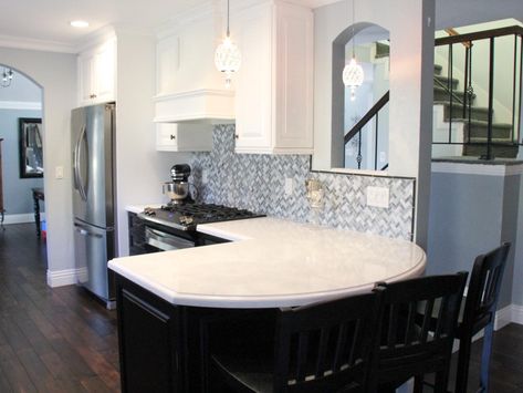 The curved peninsula in this transitional kitchen creates the perfect eat-in bar. The white and black cabinets and gray backsplash create an elegant feel in the space. The rich wood floors also allow this kitchen to feel warm and inviting. Kitchen Islands With Structural Posts, Curved Kitchen Island Ideas, Kitchen Living Room Open Concept, Kitchen Peninsula Ideas, Peninsula Kitchen Ideas, Peninsula Ideas, White Traditional Kitchen, Living Room Open Concept, White Transitional Kitchen