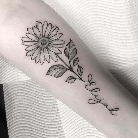 Forearm tattoo traditional black and grey stipple shading daisy with stem forming cursive script ‘Elijah Daisy Tattoo For Mom, Daisy Flower With Name Tattoo, Tattoo Flower With Words, Daisy Tattoo For Daughter, Daisy Name Tattoo Designs, Flower With Cursive Stem Tattoo, Top Forearm Tattoo Women Simple, Forearm Daisy Tattoo, Margarita Name Tattoo