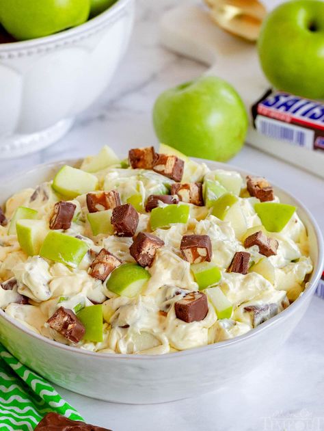 Snickers Salad is a sweet and tart dessert salad made vanilla pudding, Snickers candy bars, Granny Smith apples and cool whip or whipped cream. Top this simple Snicker Apple Salad with a drizzle of caramel sauce and you've got an easy dessert worthy of holidays, family get togethers and potlucks. Perfect for summer, fall and all year round! // Mom On Timeout Snicker Apple Salad Recipe, Bowl Desserts, Apple Salad Recipe, Snicker Apple Salad, Snickers Salad, Picnic Side Dishes, Best Apple Recipes, Fruit Desserts Easy, Snickers Candy Bar