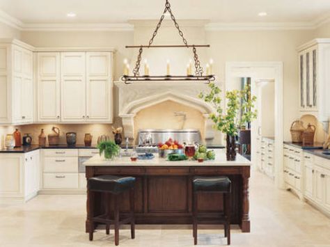 In kitchen, Lyptus cabinet doors on island with countertop of Silestone quartz; other counters in granite. Backsplash made of limestone. François & Co. cast-stone hood with Gothic detailing. Faucetry by Grohe. Thermador appliances. Wm Ohs cabinetry; boxes made of wood and pressed hay. Leather stools by Four Hands. Chandelier by Erin O'Brien. Limestone floor by Walker Zanger. Update Tuscan Kitchen, Modern Tuscan Kitchen, Tuscan Bathroom, Modern Tuscan, Kitchen Design Centre, Kitchen Vent Hood, Dallas Interior Design, Tuscan Kitchen, Kitchen Hoods