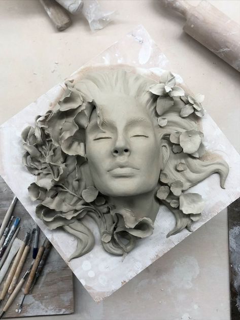 Work in progress of a ceramic sculpture by Ruth Moffatt. A portrait of a woman with seaweed, pennywort, and other coastal foliage surrounding her. Ethereal and contemplative, this sculpture was done entirely by hand without the use of any molds. The clay sculpture will be fired to cone 6. Sculpture Portrait, Woman Sculpture, Human Sculpture, Sculpture Techniques, Ceramic Art Sculpture, Sculpture Art Clay, Arte Van Gogh, Sculptures Céramiques, Bun Hairstyle