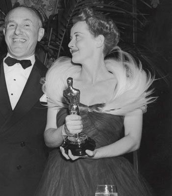 Bette Davis looked every inch the movie star at the 1939 Academy Awards when she won her second Best Actress Oscar for Jezebel (1938).  At the 1936 awards, Bette won her first Oscar for Dangerous. (1935).  Bette's dowdy dress choice that night scandalized Hollywood!  Clearly, she had a different game plan at the 1939 Oscars, look how glamorous she is here!  For more about Dangerous (1935), amazing pics, and info about the dress that scandalized Hollywood, visit my website! ❤️ #bettedavis Oscar Moments, Hollywood Decorations, Actors Studio, Oscar Awards, Golden Hollywood, Spencer Tracy, Silent Films, Bette Davis Eyes, Stars D'hollywood