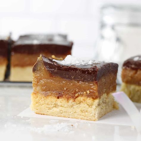 An easy millionaire shortbread made with a wholesome caramel filling, on a buttery shortbread cookie base all topped with melted chocolate ganache. Dairy free, gluten free, and ready in under an hour. Millionaire Shortbread Bars, Millionaire Shortbread Recipe, Shortbread Recipe, Millionaire Shortbread, Buttery Shortbread Cookies, Shortbread Bars, Shortbread Recipes, Healthy Desserts Easy, Salted Chocolate