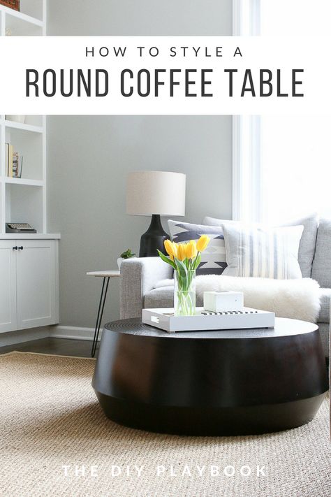 Styling a round coffee table can be tricky and there are many things to keep in mind. We always like to start with a tray, especially a rectangular tray if you have a round table. Then add coffee table books, decor items, and some storage for a finished look! #coffeetable #coffeetablestyling #coffeetabledecor #blackcoffeetable #livingroom Round Coffee Table Styling Minimal, How To Style A Round Coffee Table Tray, Styling Round Coffee Table, Circle Coffee Table Decor, Style A Round Coffee Table, Creative Coffee Table Ideas, Living Room Round Table, Tile Living Room, Surface Styling