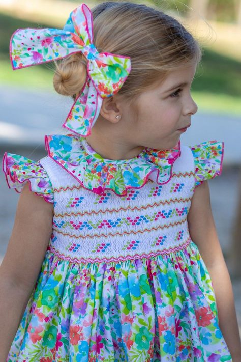 Elevate your little one's summer wardrobe with the Stunning Girls Multi-Coloured Print Smocked Summer Dress by Naxos for SS24—a captivating ensemble meticulously crafted in Spain. This dress showcases a delightful and vibrant multi-coloured print, embodying the charm and sophistication synonymous with Spanish children's wear. The smocked detailing adds an extra touch of elegance, making it a perfect choice for warm-weather occasions. Secure her size online now and be among the first to welcome t Dresses Patterns, Smocked Baby Dresses, Girls Smocked Dresses, Smocking Patterns, Girls Smock, Baby Knitwear, Spanish Fashion, Baby Dress Patterns, Heirloom Sewing