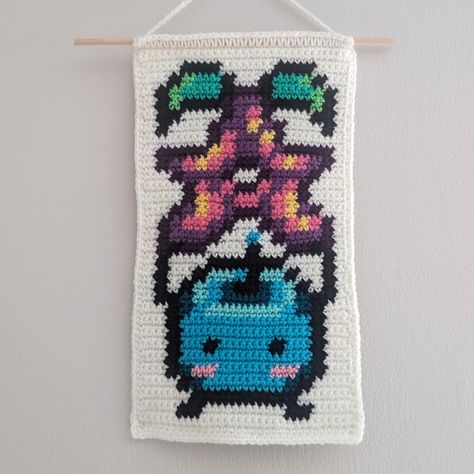 Obsessed with this tapestry I made this weekend! I've been playing Stardew Valley again recently and had to make this guy as soon as I saw the pattern from @jfoocreates 💜 Yarn: assorted acrylic weight 4 yarn, including - red heart super saver - stitch studio by Nicole (rip AC Moore) - loops and threads impeccable And random unlabeled yarns that I don't know what they are I timed making this, and it took about 4 hours total over the two days I worked on it! #stardewvalley #stardewvalleyfan... Junimo Stardew Valley Crochet Pattern, Stardew Valley Crochet Tapestry, Stardew Valley Crochet Blanket, Stardew Valley Alpha Pattern, Stardew Valley Crochet Pattern, Crochet Stardew Valley, Stardew Valley Crochet, Crochet Pixel Art, Grid Crochet