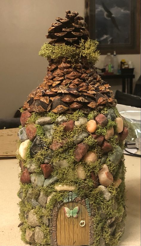 Juice bottle turned into fairy house with hot glue , rocks , moss , pine cones and store bought door Plastic Bottle Fairy House, Starbucks Bottle Crafts, Faery Magick, Castle Crafts, Jar Projects, Fairy Garden Furniture, Plastic Bottle Caps, Bottle House, Diy Water Bottle