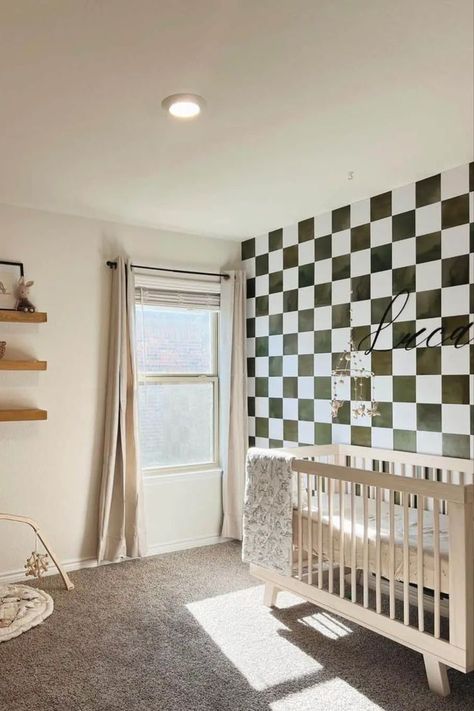 This delightful nursery showcases a light wood crib standing gracefully against a captivating black and white checkered accent wall. Stained wood floating shelves adorn the wall above a cozy beige baby play mat. Infuse warmth and light into the room with beautiful white-framed windows dressed in beige curtains. Checkered Accent Wall, Light Wood Crib, Checkered Nursery, Geometric Accent Wall, Wood Crib, Nursery Accent Wall, Kids Rooms Inspo, Accent Wall Ideas, Beige Curtains