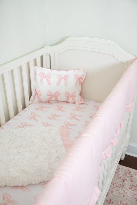 Estimated to start shipping Sept. 19. The Bows 6-pc. Crib Bedding Set features an eye-catching petal pink bow pattern. The perfect petal pink bow set for any nursery. Includes: Petal pink crib rail cover, straight, with petal pink linen ruffled trim, monogram optional Petal Pink Bows Crib Sheet, soft bamboo fabric Petal Pink Linen Crib Skirt, Gathered, deck top and split corners, 16" drop. Cream Herringbone Blanket Petal Pink Bows Baby Pillow Sham Baby Sham Pillow Insert Optional: Finish your nu Cute Pink Nursery, Pink Stripe Nursery, Love Shack Fancy Baby Nursery, Baby Girl Pink Bow Nursery, Cute Girl Nursery Ideas, Simple Pink Nursery, Vintage Disney Princess Nursery, Pink And White Nursery Ideas, Light Pink Nursery Ideas