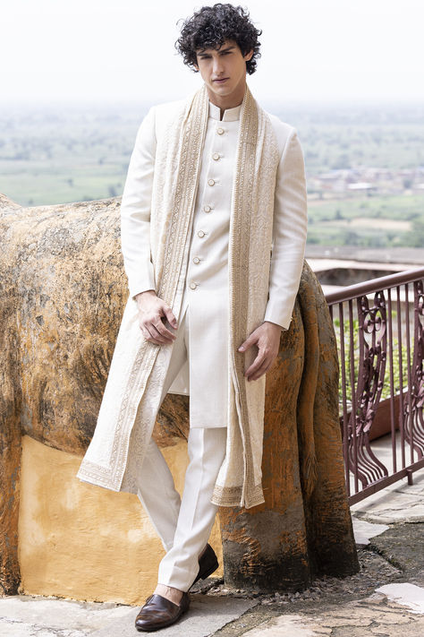 Featuring a cream sherwani in banarasi silk base. It is paired with pants and a georgette stole having aari embroidery. Perfect wear for an engagement or a wedding ceremony.  #Perniaspopupshopmen #menswear #ethnic #whatiworewastrending #ppuslove #banarasisilk #georgette #aariembroidery #sherwaniset #embroidersherwani #weddingwear Engagement Outfit For Men Grooms, Sherwani For Men Wedding Indian Groom, Cream Sherwani, Indian Wedding Suits Men, Men Sherwani, Embroidered Sherwani, Mens Wear Wedding, Wedding Dresses Men Indian, Sherwani Groom