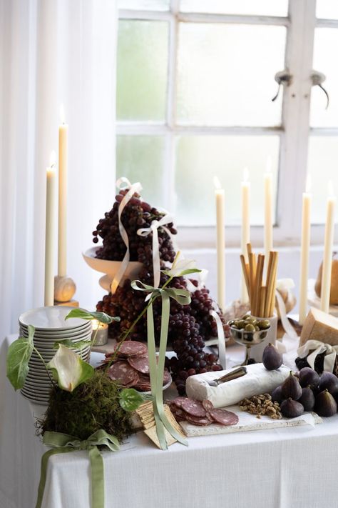 Grazing table with cheese, bread, figs, and meats. Tapered candles and green florals with bows decorate the table. Entertaining Table Settings, Modern Tablescape, Fall Dinner Party, Grazing Table, Unique Wedding Photos, Party Food And Drinks, Thanksgiving Table Settings, Dinner Decoration, Grazing Tables